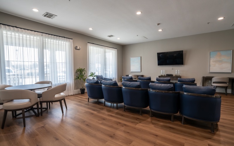 a room with a tv, table, and theater chairs