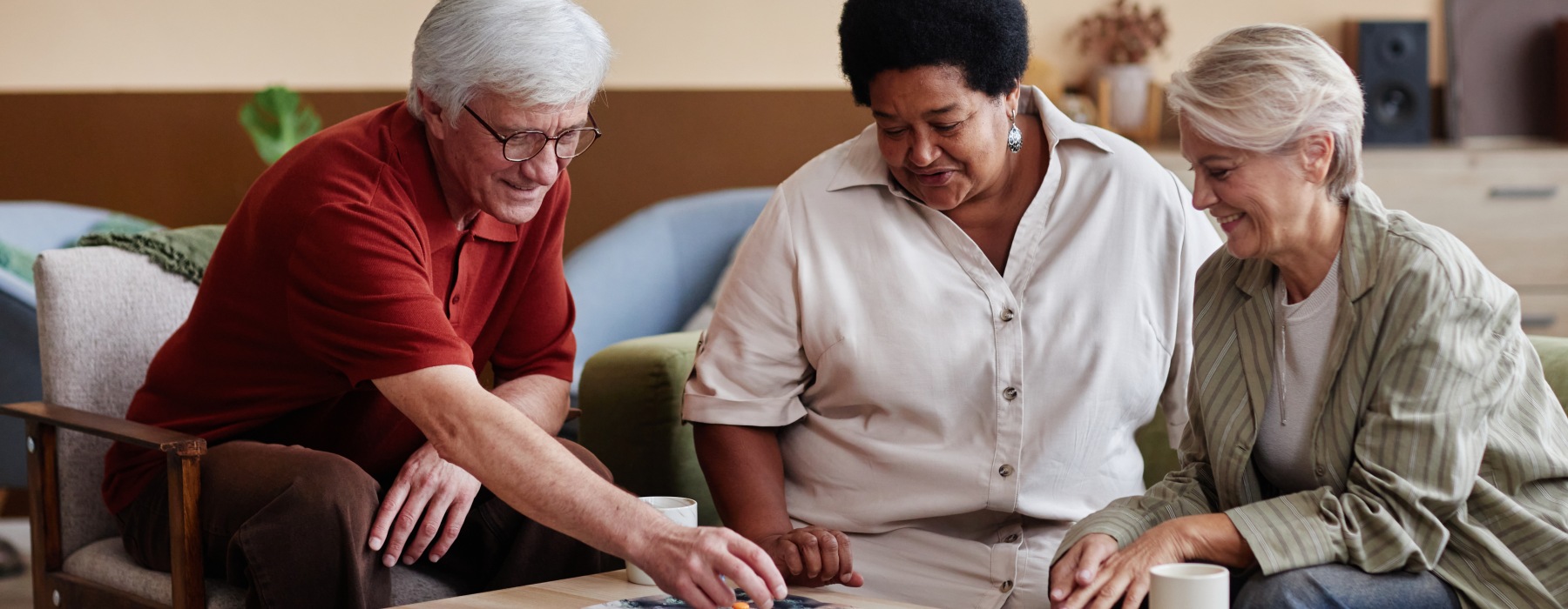 Residents and caregiver solving a puzzle